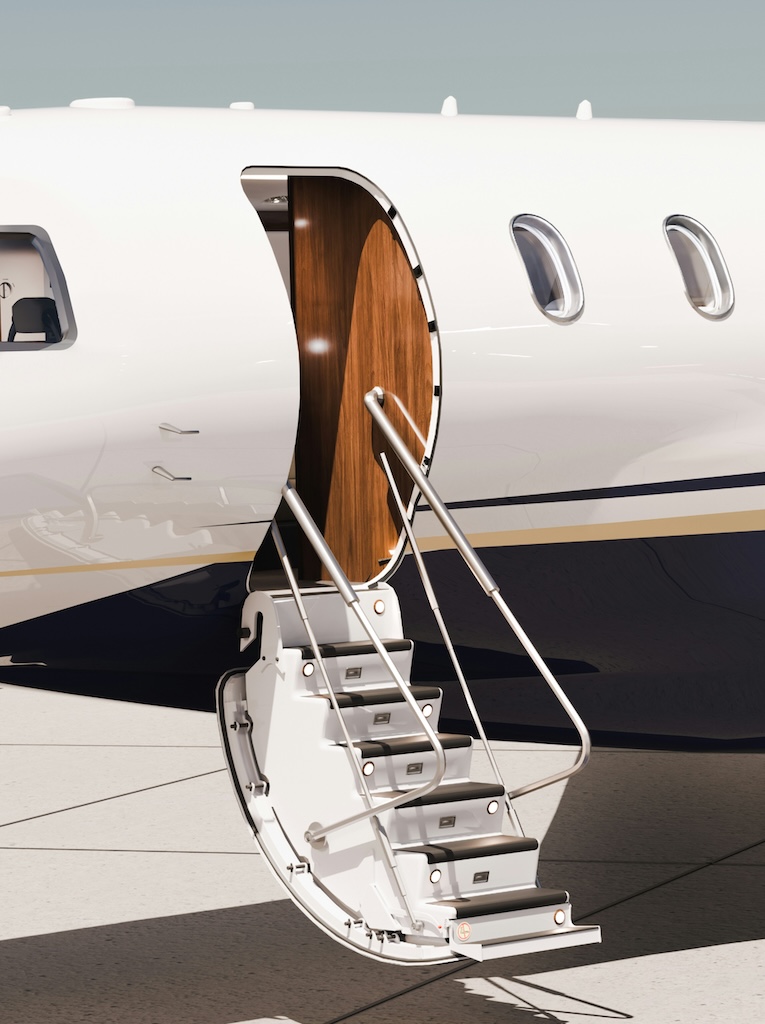 Open door of a private jet with metal boarding stairs extended on an airport tarmac.