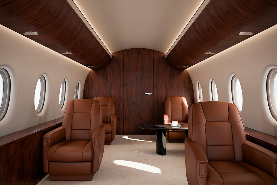 Luxury private jet interior featuring brown leather seats, multiple oval windows, dark wood wall panels with recessed lighting, and a central table on a light carpeted floor.